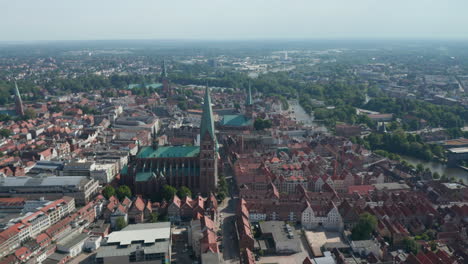 Aerial-panoramic-footage-of-old-town-lined-with-river.-Landmarks-in-UNESCO-world-heritage-site.-Luebeck,-Schleswig-Holstein,-Germany