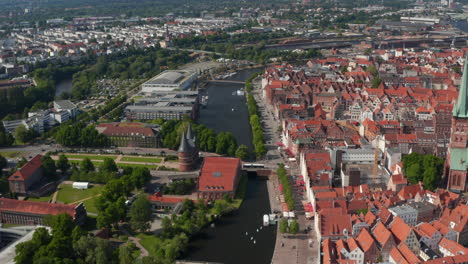 Tilt-up-a-pan-reveal-of-city.-Historic-red-brick-buildings-in-old-town-separated-by-river-from-other-neighbourhoods.-Luebeck,-Schleswig-Holstein,-Germany