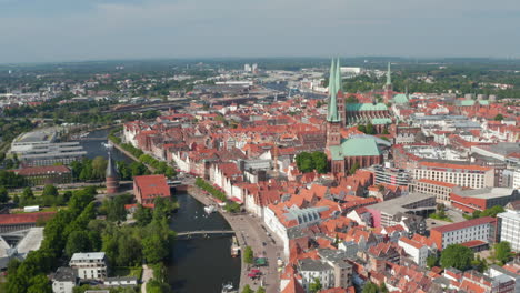 Backwards-reveal-of-city.-Aerial-view-of-historic-part-of-town-with-landmarks-in-UNESCO-world-heritage-site.-Luebeck,-Schleswig-Holstein,-Germany