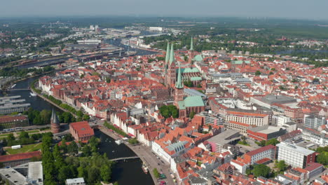 Aerial-panoramic-view-of-medieval-city-centre-with-tall-churches-towers.-Historic-town-surrounded-by-river-Trave.-Luebeck,-Schleswig-Holstein,-Germany