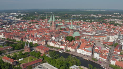 Forwards-reveal-of-medieval-city-centre.-Aerial-panoramic-view-of-historic-brick-buildings.-Luebeck,-Schleswig-Holstein,-Germany