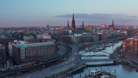 Aerial-dolly-in-view-of-Hamburg-city-center-with-famous-landmarks-and-historical-buildings-during-the-sunset