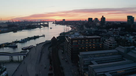 Aerial-dolly-in-view-of-Elbe-river-bank-in-Hamburg-city-center-during-sunset
