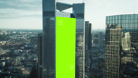 Fly-around-modern-downtown-skyscrapers-with-glossy-grass-facades.-Chroma-key-area-for-adding-your-content.-Frankfurt-am-Main,-Germany