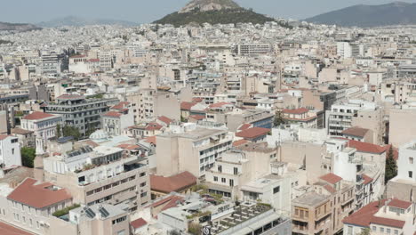 Slow-Establishing-Dolly-Aerial-towards-Mount-Lycabettus-panning-down-into-Athens-City,-Greece