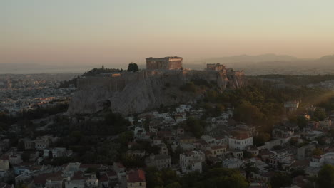 Aerial-Pan-Up-on-Mountain-with-Acropolis-of-Athens-in-Greece-with-sun-flair-in-beautiful-Golden-Hour