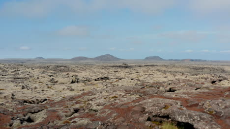 Vista-Aérea-Sobre-El-Paisaje-Surrealista-Y-Lunar-De-Islandia.-Vista-De-Drones-Sobre-El-Desierto-De-Roca-Con-Montañas-En-El-Fondo