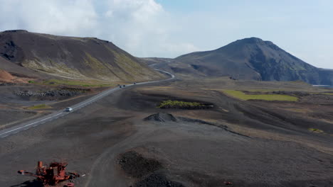 Forward-flight-through-surreal-Iceland-landscape.-Aerial-new-of-car-racing-down-the-spectacular-Ring-Road,-the-biggest-road-in-Island-that-runs-all-around-the-island