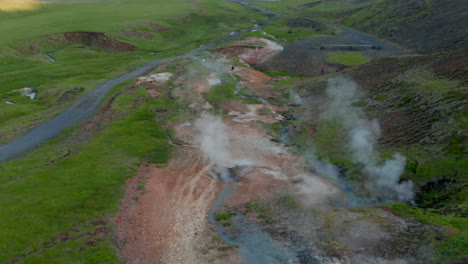 Aerial-drone-view-geothermal-area-in-Iceland-with-steaming-craters-landscape-and-tourist-exploring.-Birds-eye-of-fumaroles,-beauty-in-nature