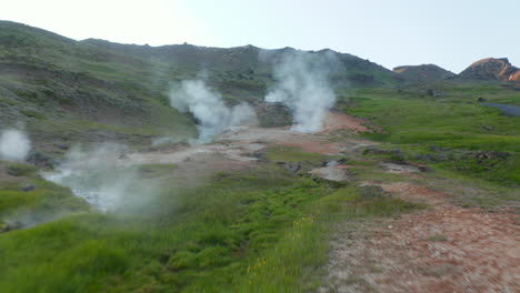 Vogelperspektive-Fliegt-In-Richtung-Geysir-Geothermalgebiet-Mit-Dampfenden-Kratern-In-Island.-Luftdrohnenansicht-Spektakulärer-Fumarolen