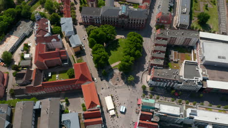 Aufsteigende-Luftaufnahmen-Eines-Kleinen-Platzes-Mit-Bäumen-Vor-Dem-Universitätsgebäude