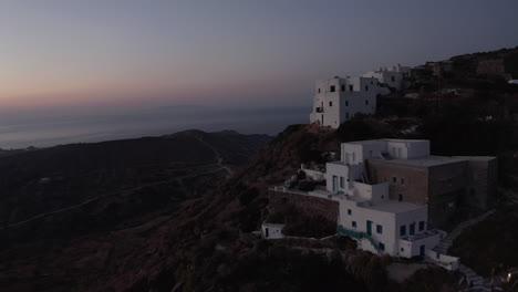Aerial-perspective-of-Little-Village-on-Milos-Island,-Greece-after-Sunset-with-Ocean-View