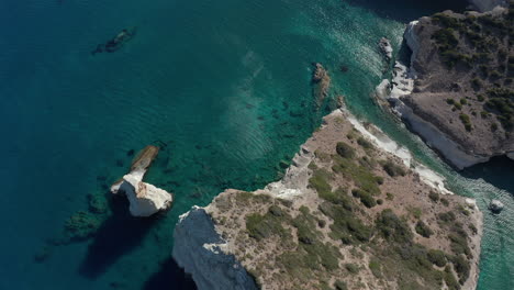 Luftaufnahme-Der-Tropischen-Bucht-In-Griechenland-Mit-Weißen-Felsen-Und-Booten-Im-Ozean