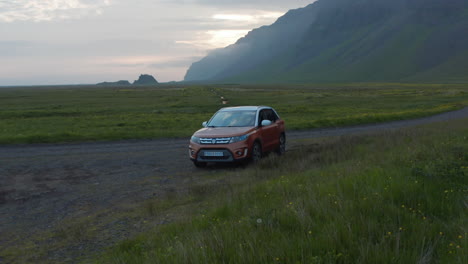 Aerial-view-car-parked-in-grassy-countryside-in-Iceland.-Drone-view-of-icelandic-highlands-with-car-parked-for-adventurous-expedition