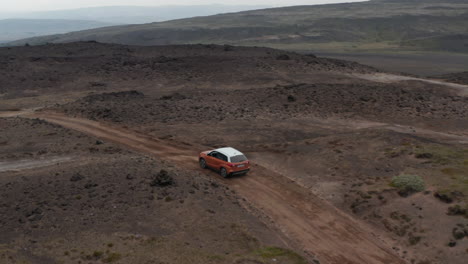 Aerial-view-car-driving-off-road-in-Iceland-highlands.-Drone-view-4x4-car-hitting-dirt-road-adventurous-exploring-icelandic-countryside