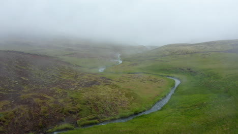 Vogelperspektive-Von-Reykjadalur-Hot-Spring-River-Pools-Valley-An-Nebligen-Tagen.-Nebliger-Drohnenblick-Auf-Den-Geothermischen-Heißen-Fluss,-Der-In-Der-Grünen-Landschaft-Islands-Strömt