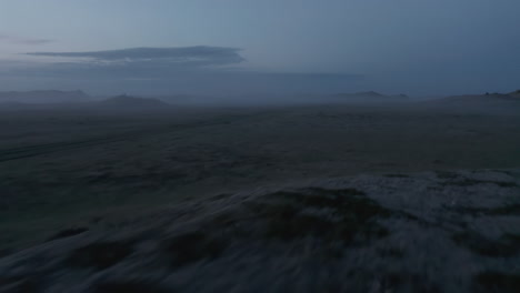 Aerial-view-or-rural-Iceland-landscape-covered-with-fog.-Car-stopped-in-wilderness-of-icelandic-countryside-and-tourist-enjoying-misty-sunset-of-Iceland-highlands