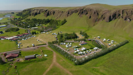 Aerial-view-of-green-Iceland-countryside-with-campsite-for-tourist.-Drone-view-of-little-village-in-green-meadow-of-Icelandic-highlands