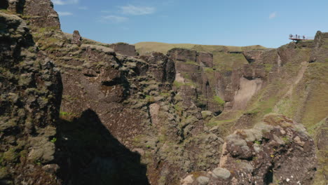 Drone-view-of-Fjadrargljufur-Iceland-canyon-with-large-cliffs-and-green-moss-grass-hills.-Aerial-view-of-rock-formation-of--Fjadrargljufur-canyon.-Beauty-on-earth.-Fjadrargljufur-canyon