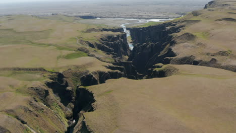 Aerial-view-of-majestic-canyon-of-Fjadrargljufur-in-south-Iceland-and-Fjadra-river-flowing-through-it.-Beauty-in-nature.-Drone-view-of-panorama-of-the-valley-of--Fjadrargljufur-canyon-and-the-gorge