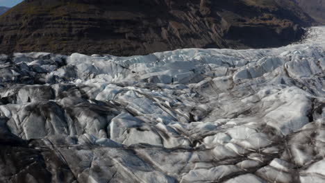 Aerial-view-of-glacier-texture-at-Breidamerkurjokull-glacier-tongue-in-Iceland.-Scenic-drone-view-of-snow-capped-icelandic-mountains.-Amazing-in-Nature.-Vatnajokull-national-park