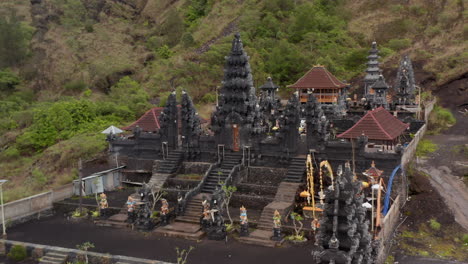 Ascending-pedestal-aerial-view-of-stunning-black-stone-pillars-and-colorful-statues-at-the-Pura-Pasar-Agung-Hindu-Temple-on-the-side-of-Mount-Agung-in-Bali