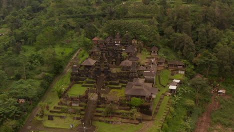 Old-religious-buildings-at-Besakih-Hindu-Temple-in-Bali,-Indonesia.-Aerial-view-of-stunning-old-temple-buildings-with-tall-pagodas-surrounded-by-tropical-rainforest
