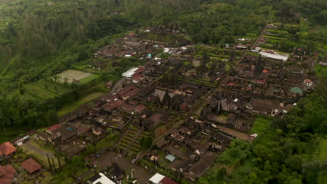 Aerial-view-of-tourists-and-local-people-at-the-Besakih-Temple-in-Bali,-Indonesia.-Circling-shot-of-old-ancient-sculptures-and-buildings-at-the-famous-Hindu-temple