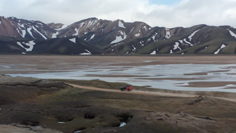 Aerial-view-off-road-car-driving-dirt-road-isolated-desert-rock-highlands-in-Iceland.-Scenic-landscape-drone-view-of-Icelandic-road-and-beautiful-birds-eye-view-of-the-nature-countryside