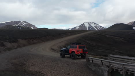 Drone-view-jeep-car-parked-on-dirt-road-in-Iceland-countryside.-Expedition-and-adventure.-Aerial-view-of-a-offroad-vehicle-stopped-on-a-trail-in-icelandic-highlands-ready-to-discover-wilderness