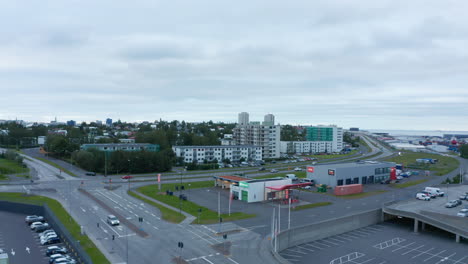 Aerial-ascending-footage-of-town-with-buildings-and-transport-infrastructure.-Sea-coast-in-background.-Reykjavik,-Iceland