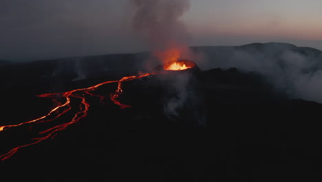 Vista-Aérea-Del-Paisaje-Volcánico-Al-Amanecer.-Cráter-Activo-Que-Brota-Lava-Fundida-Y-Corrientes-De-Material-Caliente-En-Pendiente.-Volcán-Fagradalsfjall.-Islandia,-2021