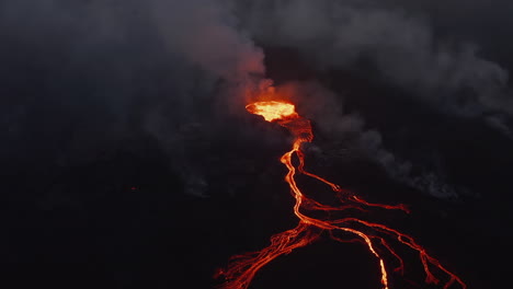 Slide-and-pan-view-of-active-volcano-crater-at-night.-Aerial-view-of-flowing-lava-streams.-Fagradalsfjall-volcano.-Iceland,-2021