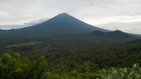 Mann,-Der-Zum-Aussichtspunkt-Für-Den-Berg-Agung-über-Dem-Regenwald-In-Bali-Läuft.-Tourist,-Der-Den-Großen-Berggipfel-Betrachtet,-Der-Sich-über-Dem-Dschungel-In-Indonesien-Erhebt