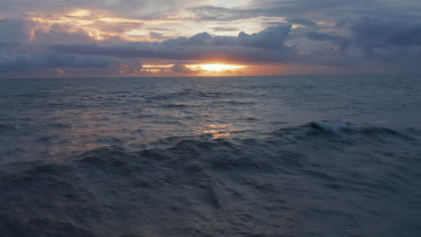Small-waves-on-ocean-surface-during-warm-evening-light.-Blue-ocean-in-orange-evening-sunset-light-in-Bali