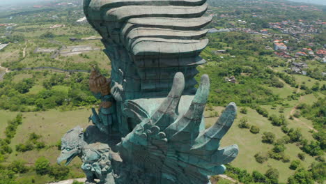 Close-up-aerial-view-circling-around-Garuda-Wisnu-Kencana-statue-in-Bali,-Indonesia.-Tall-religious-monument-to-important-Hindu-deity-Vishnu