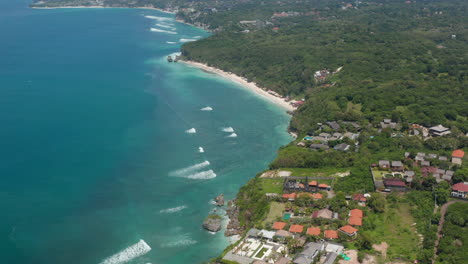 Panoramic-aerial-view-of-luxury-holiday-homes-and-resorts-on-top-of-the-cliff-overlooking-blue-ocean-in-Bali,-Indonesia