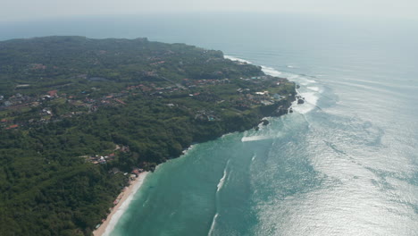 Aerial-view-of-luxury-houses-on-tropical-coastline-of-Bali.-Panoramic-view-of-Bali-coastline-with-lush-green-vegetation-and-sandy-beaches-by-the-ocean