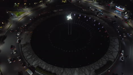 Overhead-aerial-view-of-busy-night-traffic-on-a-roundabout-in-Jakarta,-Indonesia