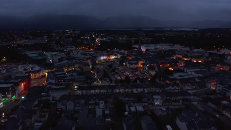 Aerial-panoramic-shot-of-town-after-sunset.-Evening-footage-of-colour-illuminated-facades-in-city-centre.-Killarney,-Ireland