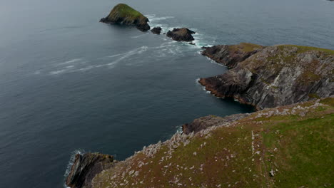 Aerial-footage-of-sea-coast-with-several-rock-islets-at-Dunmore-Head.-Tilt-down-on-steep-escarpment.-Ireland