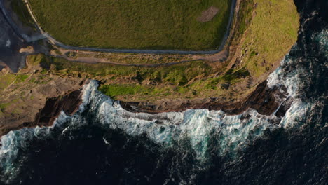 Aerial-birds-eye-overhead-top-down-view-of-waves-crashing-to-coastal-cliff.-Amazing-natural-scenery.-Cliffs-of-Moher,-Ireland