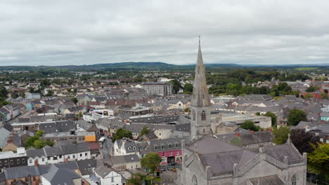 Aerial-footage-of-Cathedral-of-Saints-Peter-and-Paul-and-town-in-background.-Old-stone-religious-building-with-tall-spire.-Ennis,-Ireland