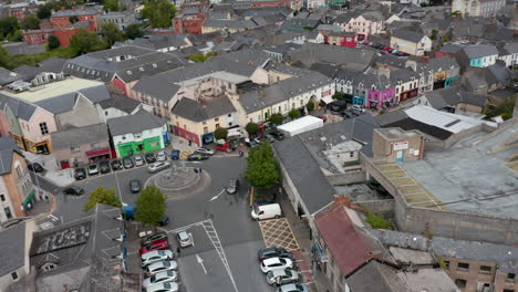 Circular-shot-of-town-centre.-Square-with-roundabout-and-parked-cars.-Shopping-streets-around.-Ennis,-Ireland