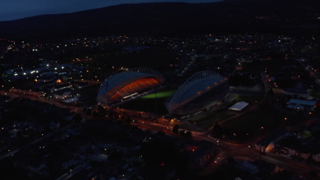 Slide-and-pan-footage-of-light-show-and-turning-on-main-lights-on-football-stadium.-Aerial-shot-of-sport-centre-in-city-at-night.-Limerick,-Ireland
