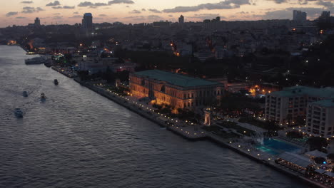 Schöner-Ciragan-Palast-Kempinski-Am-Ufer-Des-Bosporus-In-Istanbul-In-Der-Abenddämmerung,-Luftaufnahme