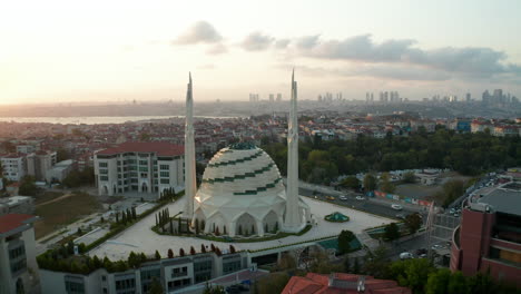 Futuristische-Moschee-Bei-Schönem-Sonnenuntergang-In-Istanbul,-Modern-Aussehender-Tempel-Bei-Sonnenuntergang-Mit-Stadtbild,-Luft-Rückwärts