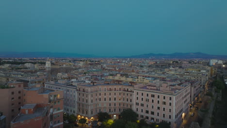 Blocks-of-apartment-buildings-lined-by-streets-and-ancient-city-walls.-Forwards-fly-above-city-at-dusk.-Rome,-Italy