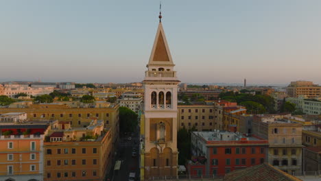 Fly-around-beautiful-tower,-morning-city-in-background.-Circular-aerial-view-of-buildings-in-urban-borough.-Rome,-Italy