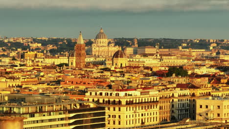 Fly-above-large-city-at-sunset.-Zoomed-aerial-footage-of-historic-buildings-and-towers,-Monumental-St.-Peters-Basilica-in-Vatican-City-in-background.-Rome,-Italy